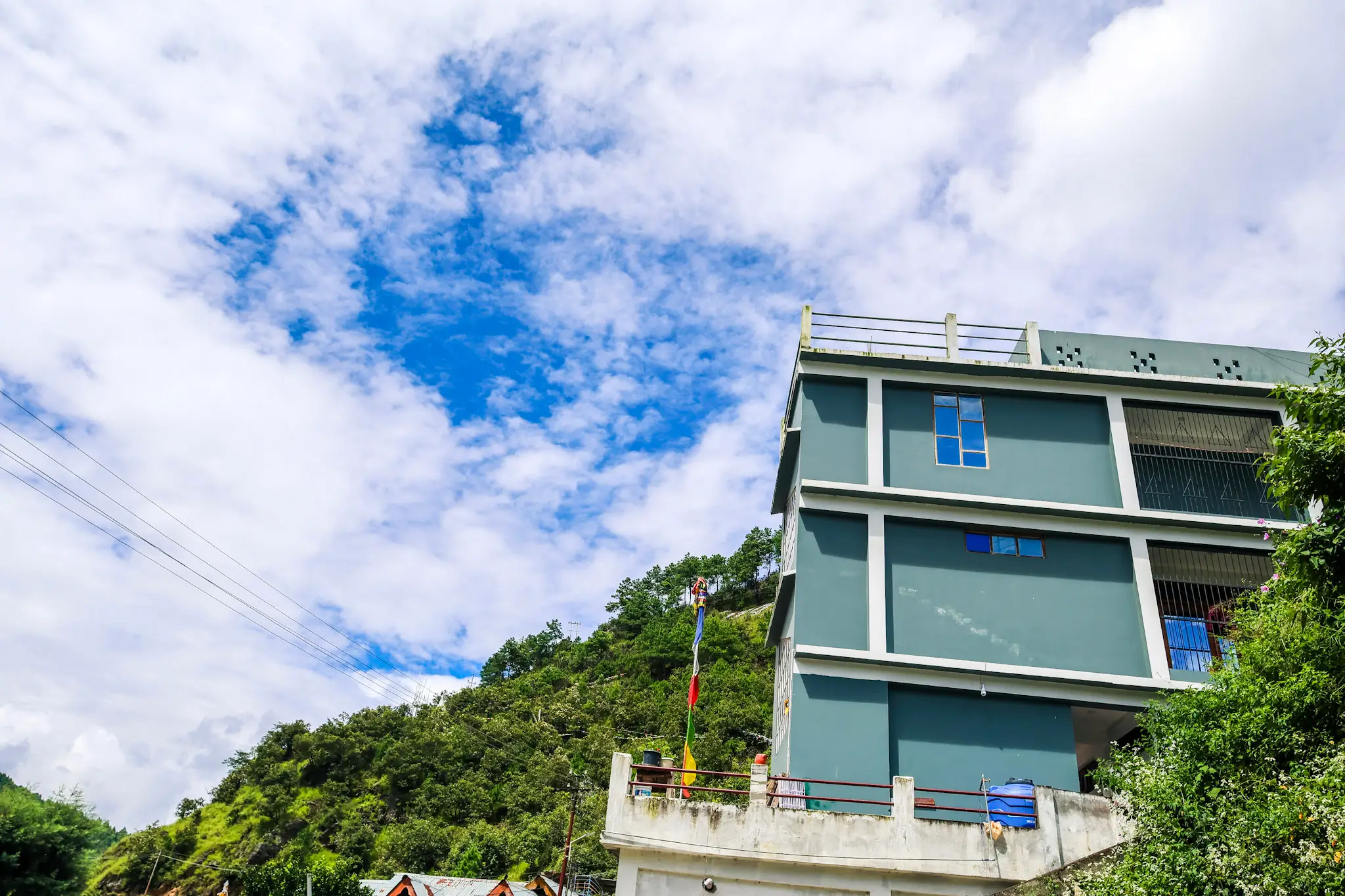 Daisy Homestay exterior view with traditional Arunachali architecture and mountain backdrop
